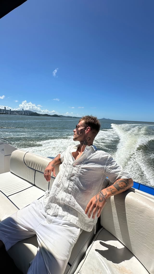 Homem relaxando em um barco no mar, vivendo sua rota de fuga do CLT